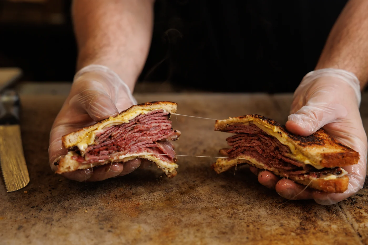 A Bagel Boyz pastrami sandwich pulled apart with melted cheese